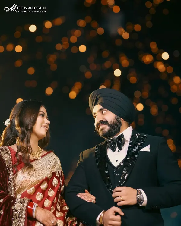 A classic, romantic portrait of a couple on their reception night, framed against a beautiful bokeh of distant lights. This shot is all about capturing the magic and intimacy of the evening.