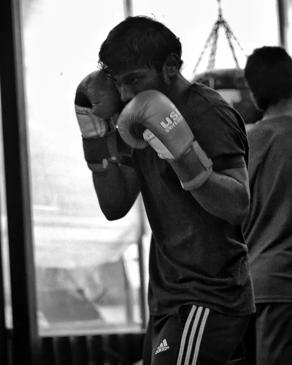 A fighter working on his form, keeping his guard tight while training. The bag doesn't hit back, so your discipline has to be perfect.