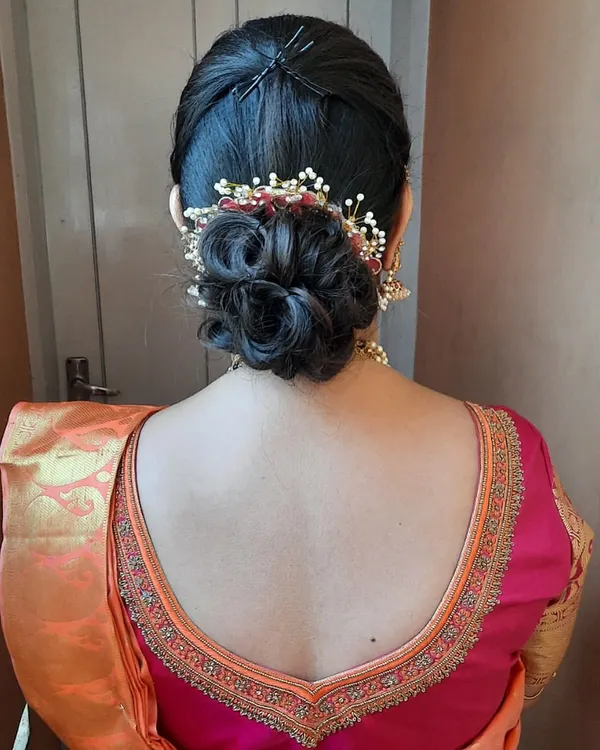 An elegant and intricate low messy bun. This hairstyle is perfect for a reception or engagement, and I've added a delicate, custom hair accessory to complement the saree.