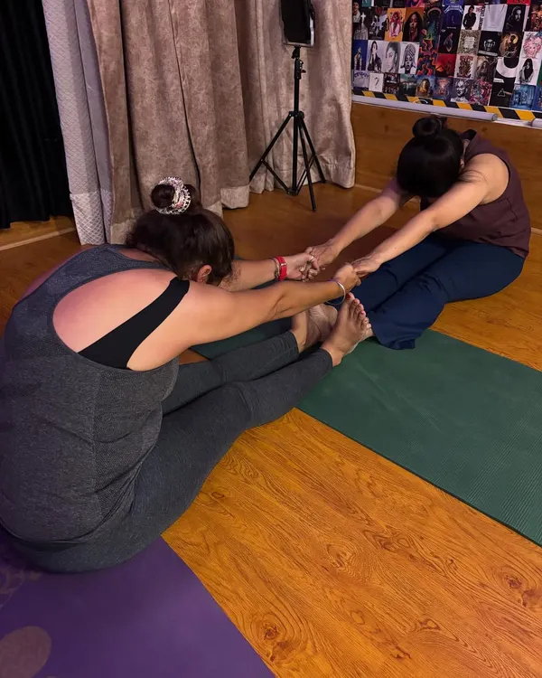A perfect day includes a good stretch. Here, I'm assisting a student in a partner stretch to deepen her forward bend and increase hamstring flexibility.