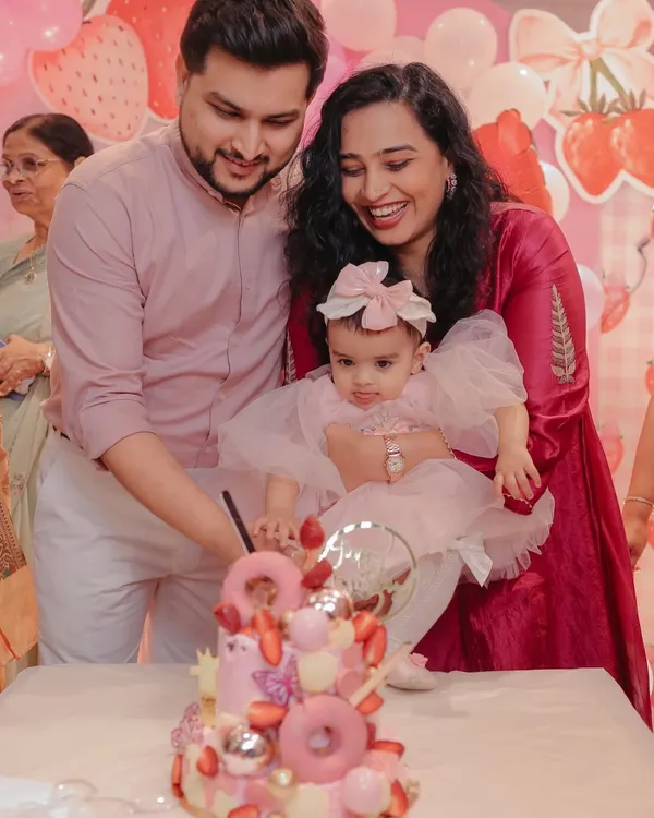 This photo from Gauri's first birthday showcases the stunning strawberry-themed cake from a local baker. By tagging and praising the creator, I show how I support and promote small businesses through my celebration content.