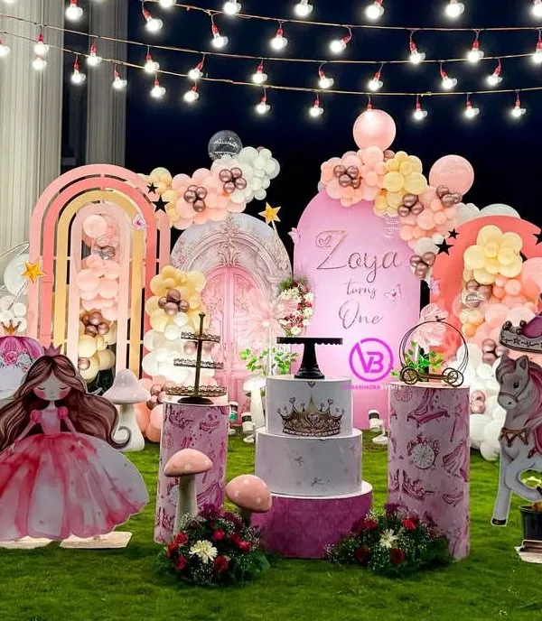 We transform outdoor spaces into fairytale settings. This first birthday party features a complete princess theme with custom props like a carousel and castle, marquee letters, and beautiful floral balloon arrangements under romantic string lights.