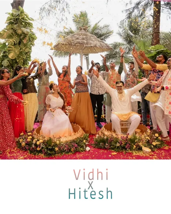 The perfect Haldi group shot. A moment of celebration as friends and family shower the couple with flower petals, capturing the peak of the fun and energy.