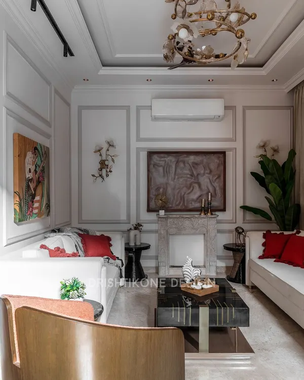 This living room is a study in classic elegance, featuring a custom-designed natural stone fireplace as the focal point. We used wall mouldings and a refined color palette, adding warmth with pops of red in the cushions for a timeless yet inviting feel.