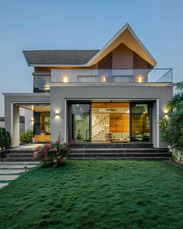 This is the Tranquil Mango Haven, a retreat villa where architecture and landscape become one. As dusk settles, the lighting design brings the space to life, highlighting the seamless transition from the warm interiors to the cool, manicured lawn, embodying my goal of dissolving the boundaries between inside and out.