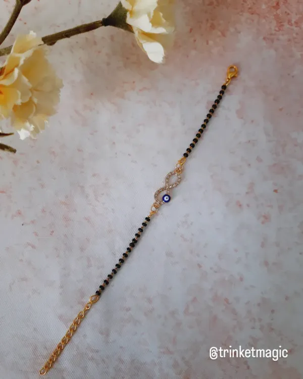 Protection meets elegance with this evil eye mangalsutra bracelet. It features an infinity symbol encrusted with crystals and a small evil eye, blending modern style with traditional meaning.