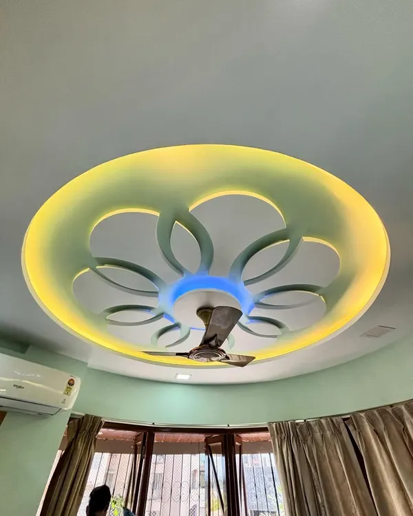 A side view of the completed floral-patterned false ceiling. The design adds depth and character, integrating the ceiling fan seamlessly while providing beautiful, layered lighting.