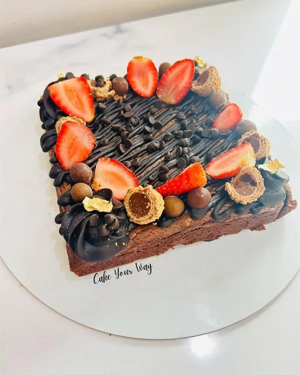 This isn't just a brownie, it's a brownie cake. I take my signature fudgy brownie and load it up with chocolate drizzle, fresh strawberries, and an assortment of chocolate treats for an over-the-top dessert experience.