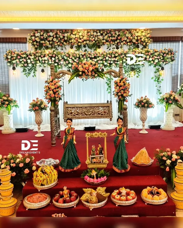 A full view of our grand naming ceremony setup, featuring the ornate wooden jhoola, abundant floral arrangements, and a stage filled with traditional offerings and Marapachi Bommai dolls.