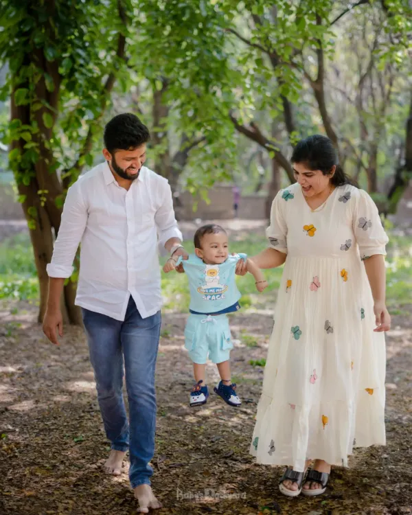 A gentle walk through the park, with mom and dad helping their little one take his first swinging steps. These candid moments are what outdoor family photography is all about.