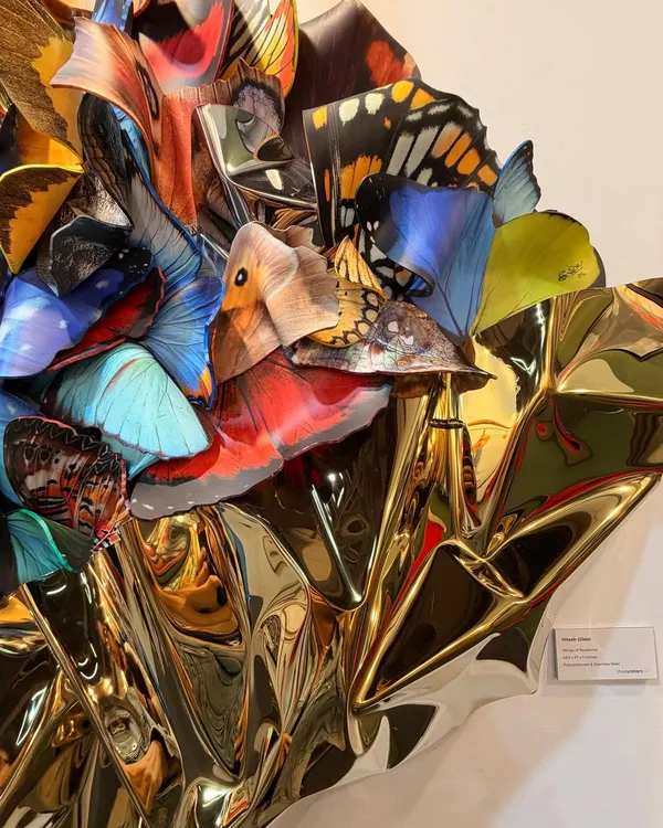 A close-up of "Wings of Resilience." Each polycarbonate butterfly wing is carefully placed to create a layered, three-dimensional effect against the golden steel.