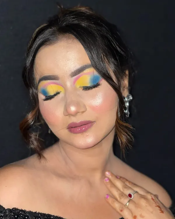 A close-up of a vibrant, multi-colored eyeshadow look, blending yellow, pink, and blue for a creative effect.