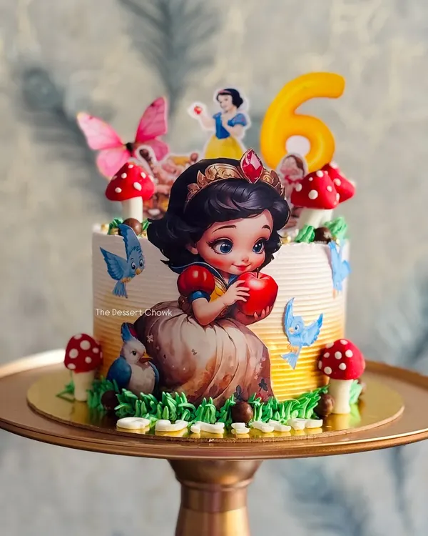 A fairytale come to life with this Snow White themed tall cake. I used edible prints and fondant mushrooms to create an enchanted forest scene for a 6th birthday.