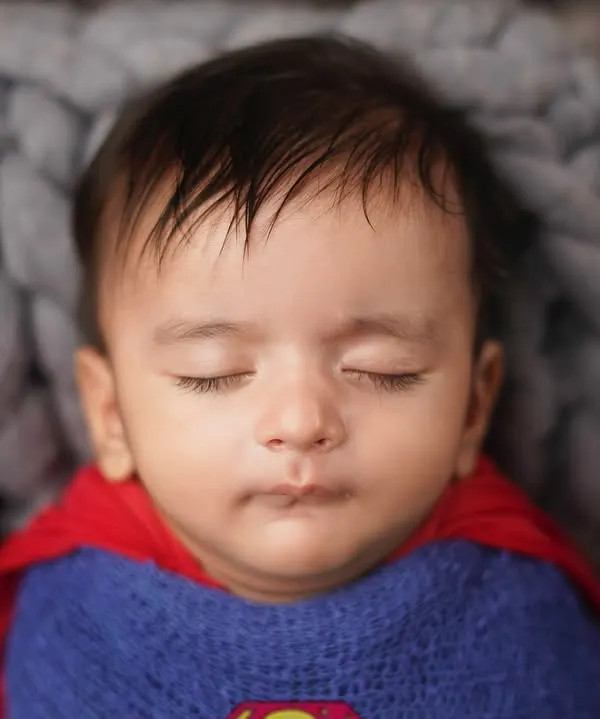 A close-up of our little Superman, sleeping peacefully. Even superheroes need their naps. Themed newborn shoots are a fun way to incorporate your family's interests.