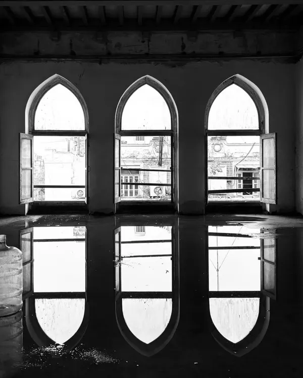 Reflections in a flooded room of a new project site. Water and light reveal the elegant arches of the windows, hinting at the building's past and offering a moment of poetry before the rigorous work of restoration begins.