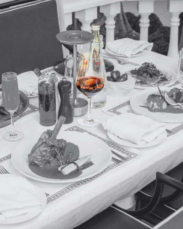 A glass of rich red wine is the centerpiece of this table setting. Wine is an essential part of the Mediterranean dining culture, and we help you find the perfect pairing for your meal.