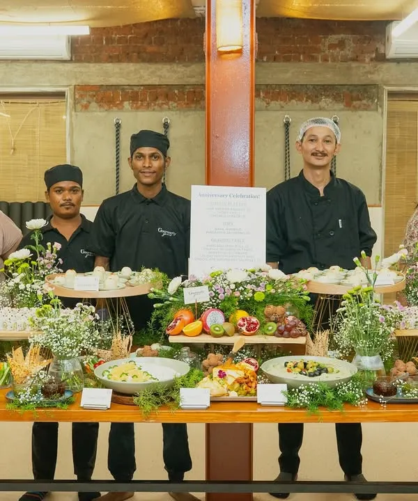 The Gourmetly Yours team posing proudly behind a beautiful grazing table at a corporate anniversary event. We are thrilled to bring our signature touch to every celebration.