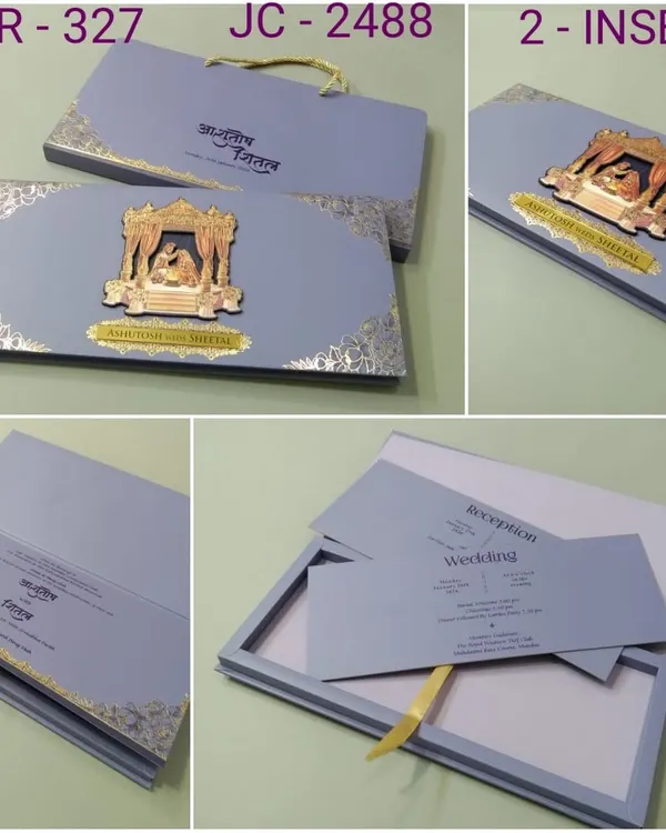 This premium boxed invitation in a sophisticated grey-blue features a 3D metallic emblem of a wedding ceremony. The set includes a matching carry bag and multiple inserts for a complete luxury experience.