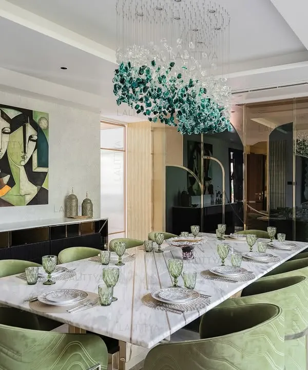 This dining room was planned as a central moment for gathering. The layout allows the design to breathe, with tonal greens in the chairs, soft marble textures on the table, and a sculptural chandelier suspended like an artwork.