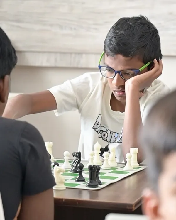 The heart of chess is deep concentration. Here, a young student contemplates his next move, showcasing the intense focus and critical thinking we cultivate in our classes. We teach children not just to play, but to think several steps ahead.