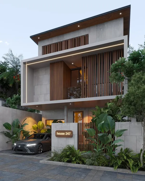 This Bangalore project showcases a bold, modern facade using a mix of concrete, stone, and vertical wooden slats. The design emphasizes geometric forms and integrated lighting to create a strong visual statement on a compact urban plot.