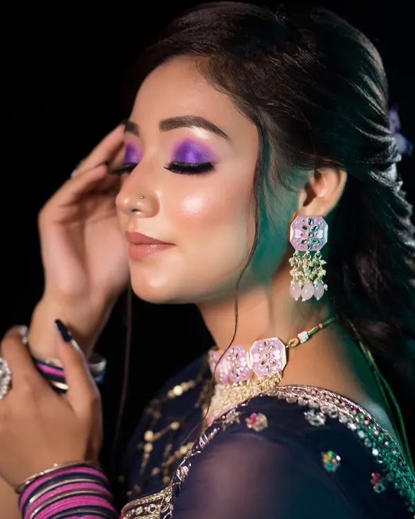 A bold and artistic party look. The vibrant purple eyeshadow is the star of the show, creating a dramatic and eye-catching effect perfect for a sangeet night.