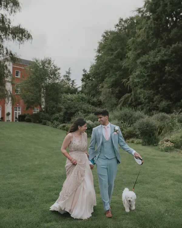 A lovely candid moment from a wedding in Hampshire, UK, as the couple takes a stroll with their furry friend. We love incorporating personal elements like pets into our couple portraits.