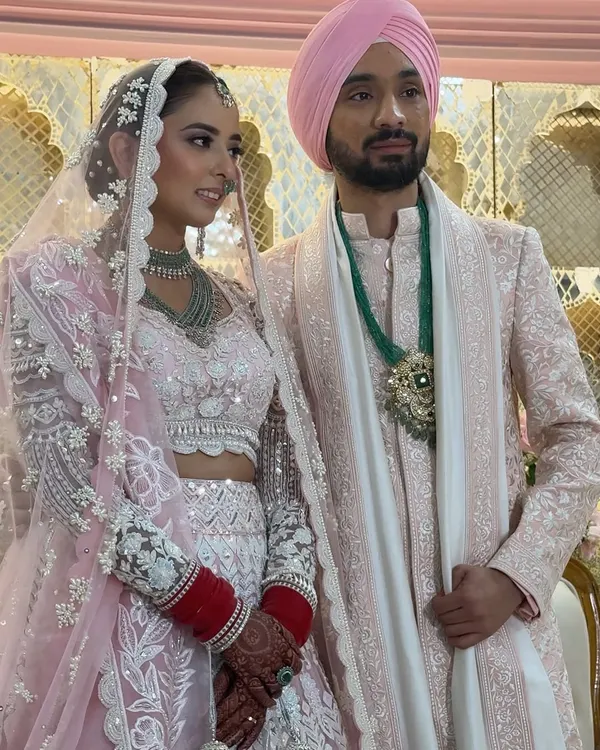 A beautiful couple portrait from a pastel-themed Anand Karaj. The bride's makeup is soft and romantic, with pink tones that perfectly complement her stunning Manish Malhotra lehenga.