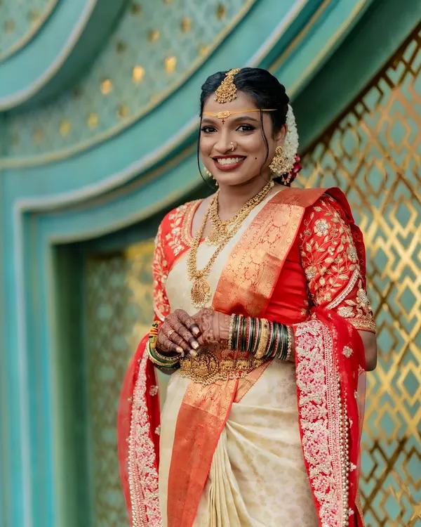 For this beautiful Telugu bride, we achieved a flawless look with a pre-pleated Kanjivaram silk saree. The off-white and red combination, paired with traditional temple jewelry, created a radiant and timeless bridal appearance for her big day.