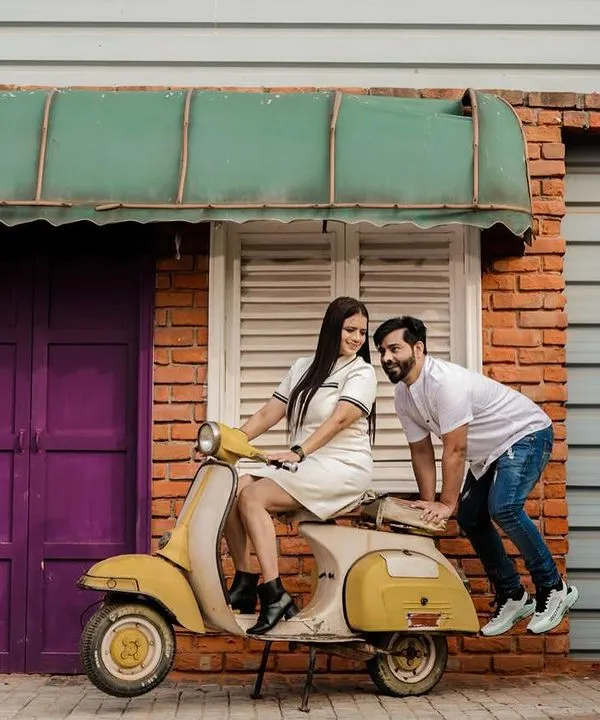 Let's have some fun with props. This couple wanted a playful vibe, so we used a vintage scooter against a quirky, colorful brick wall. This kind of shot is full of energy and personality, perfect for couples who want their pre-wedding photos to be lighthearted and memorable.