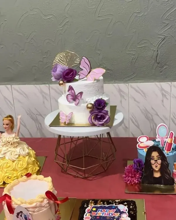 A close-up of the beautiful, professional-looking designer cakes my students learn to create, including a tiered cake with butterflies, a doll cake, and a themed birthday cake.