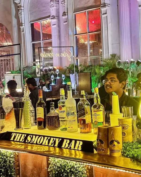 A vibrant 'Gin O'Clock' neon sign sets the mood at this wedding event. I designed this setup with a mix of modern lighting and lush greenery to create an inviting and high-energy gin bar.