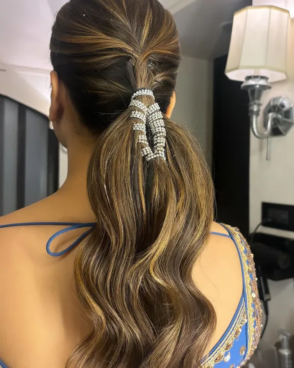 This is a new favorite of mine: a braided ponytail with a sparkling accessory. I created a small braid at the crown and wrapped the base of the wavy ponytail with a beautiful rhinestone cuff for a touch of glamour.