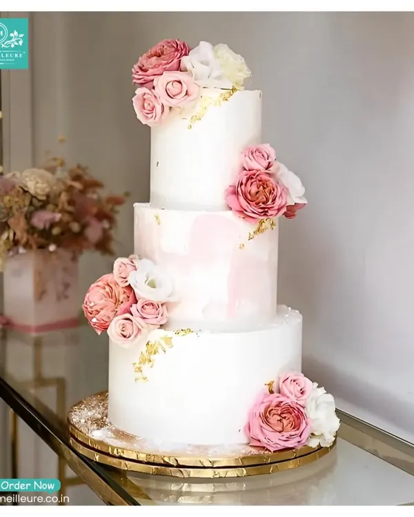 This three-tiered Parisian-inspired cake is a perfect example of the elegant centerpieces I create for weddings and grand celebrations. It features a delicate pink watercolour effect, touches of edible gold leaf, and is adorned with beautiful fresh roses.