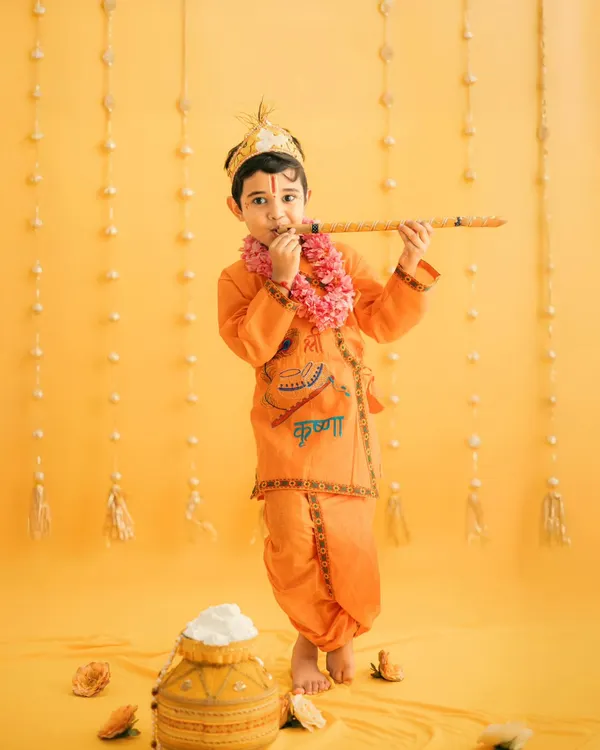 Our little Krishna, looking divine with his flute. We use a vibrant yellow backdrop and traditional props to create authentic and beautiful Janmashtami portraits.