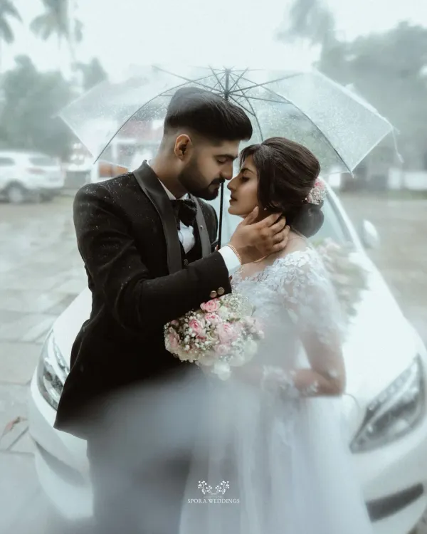 A quiet moment shared between a bride and groom, shielded from the world under an umbrella. I believe in creating these pockets of intimacy, even amidst the grandest celebrations, ensuring your wedding day is filled with personal, unforgettable memories.