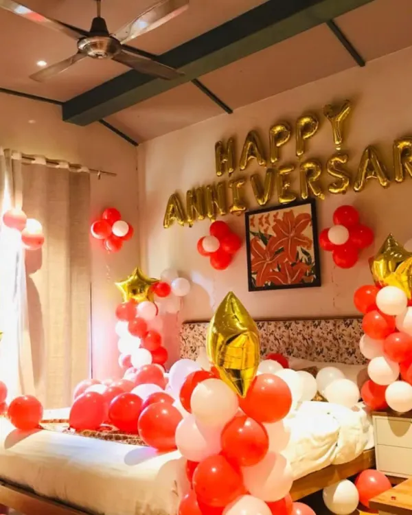 A simple yet beautiful bedroom decoration to celebrate your anniversary. This package includes "Happy Anniversary" foil balloons on the wall, with balloon bunches and star foils in a classic red, white, and gold color scheme.