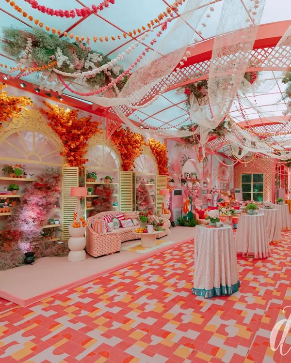 This wide-angle shot captures the immersive 'La Dolce Vita' theme for a luxury engagement party. Notice the vibrant color palette, custom flooring, and distinct seating areas that transport guests to a sun-kissed Italian piazza.
