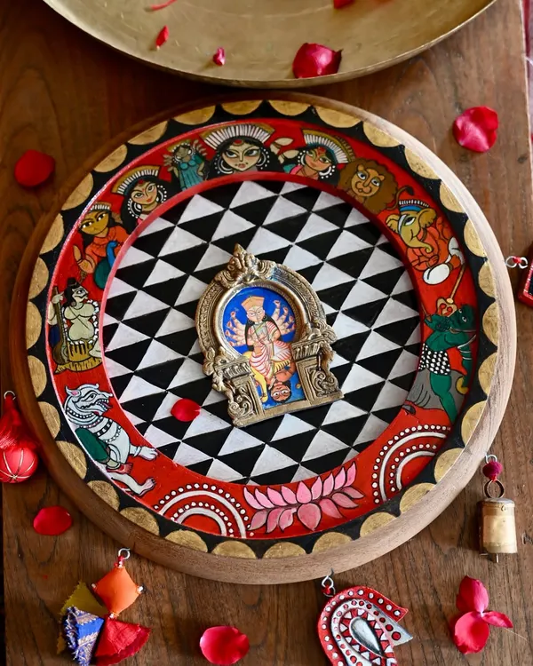 A hand-painted tribute to the goddess Durga, framed within a restored vintage clock and a salvaged Prabhavali. The artwork is inspired by puja pandals and features the Shakti parivaar, blending Pattachitra tradition with restoration art.