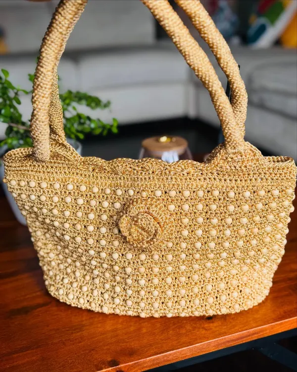 A full view of my handcrafted gold bag, intricately woven with beads for a classic look. The scalloped edge and detailed flower add a touch of timeless elegance.