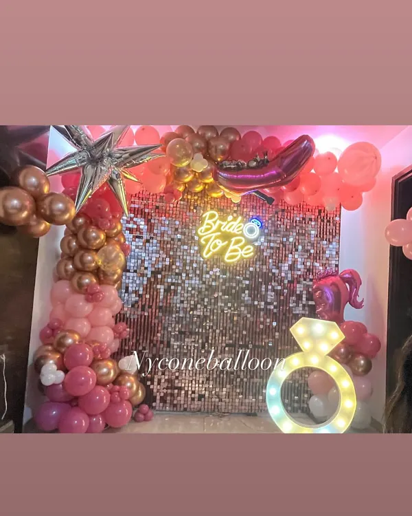 The complete setup for a fun 'Bride to Be' party. The pink sequin wall, neon sign, and balloon arch create a fantastic photo booth for the bride and her friends.