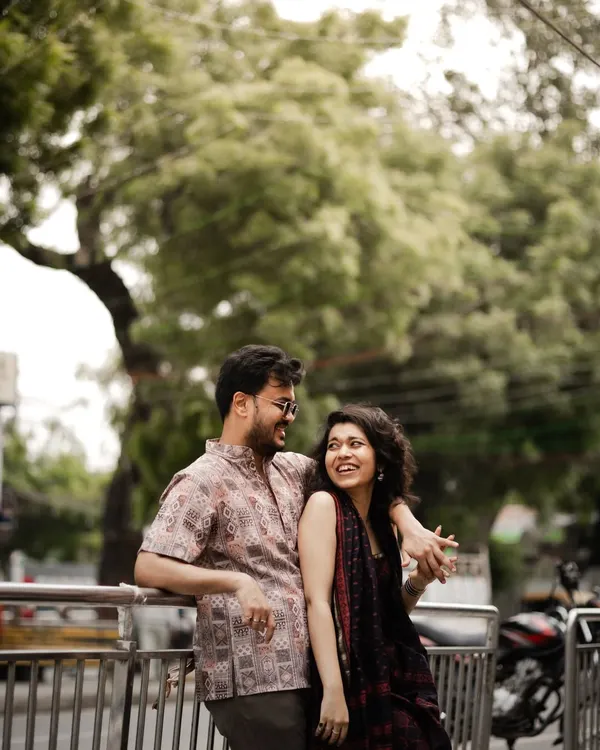 A candid, happy moment on a city street, capturing the effortless chemistry and laughter between the couple.