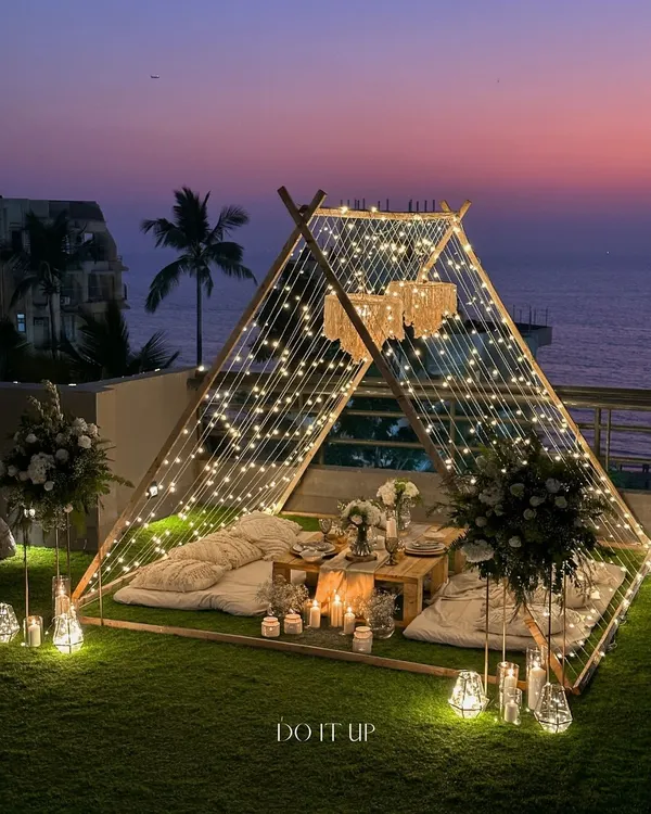 A magical evening under the stars. I designed this intimate teepee setting for a special proposal, using layers of fairy lights and soft cushions to create a space that felt like a private world, perfect for a once-in-a-lifetime moment.