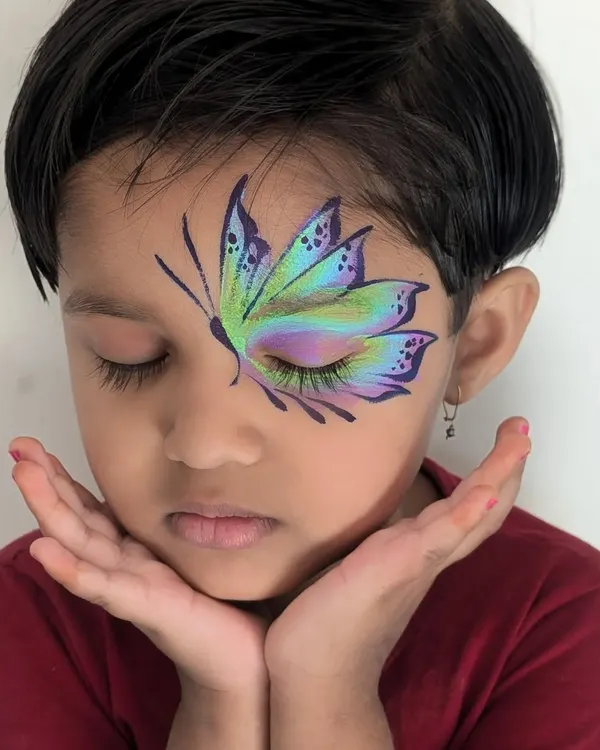 This intricate butterfly design is one of my most requested pieces for children's parties. I use multi-color cakes and fine brushes to create this beautiful, blended effect that looks magical when kids flutter their eyes.