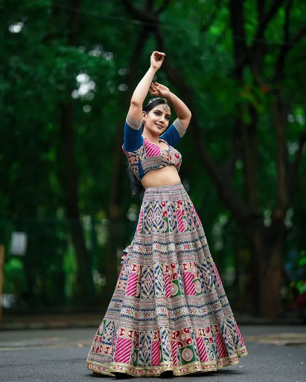 A full-length shot capturing the dynamic movement of a traditional patterned lehenga. This kind of image is essential for lookbooks to show how the garment flows.