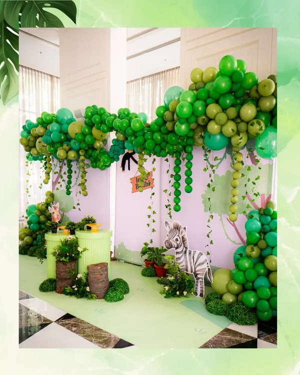 Welcome to the jungle. We created a lush, immersive world for a wild-themed birthday, using layers of green balloons to form a jungle canopy and cute animal props to bring the safari to life.