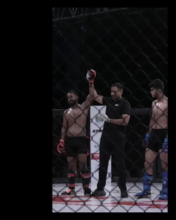 Our head coach, a certified referee, raising a fighter's hand in victory. His experience inside the cage as an official provides invaluable insight for our team.