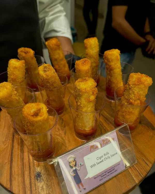 Crispy cigar rolls served in individual glasses with a sweet chili sauce. This presentation is elegant, easy for guests to handle, and perfect for house parties.