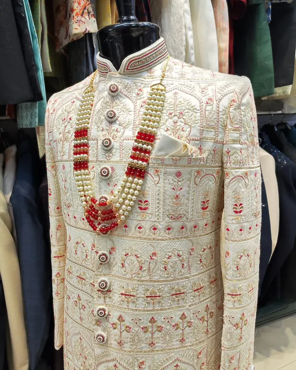 This is what I call extravagance for the groom's special day. A fully embroidered off-white sherwani paired with a striking red and pearl mala creates a look of pure royalty.