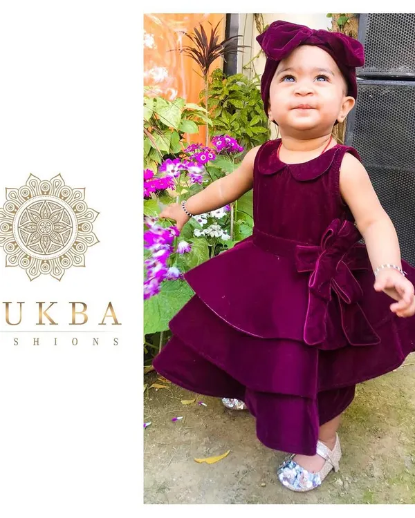 This little one is radiating pure joy in her custom-designed velvet party dress. I crafted this piece with a rich magenta velvet, featuring a playful tiered skirt, a classic Peter Pan collar, and a matching statement bow headband to create a look that's both whimsical and elegant for any celebration.